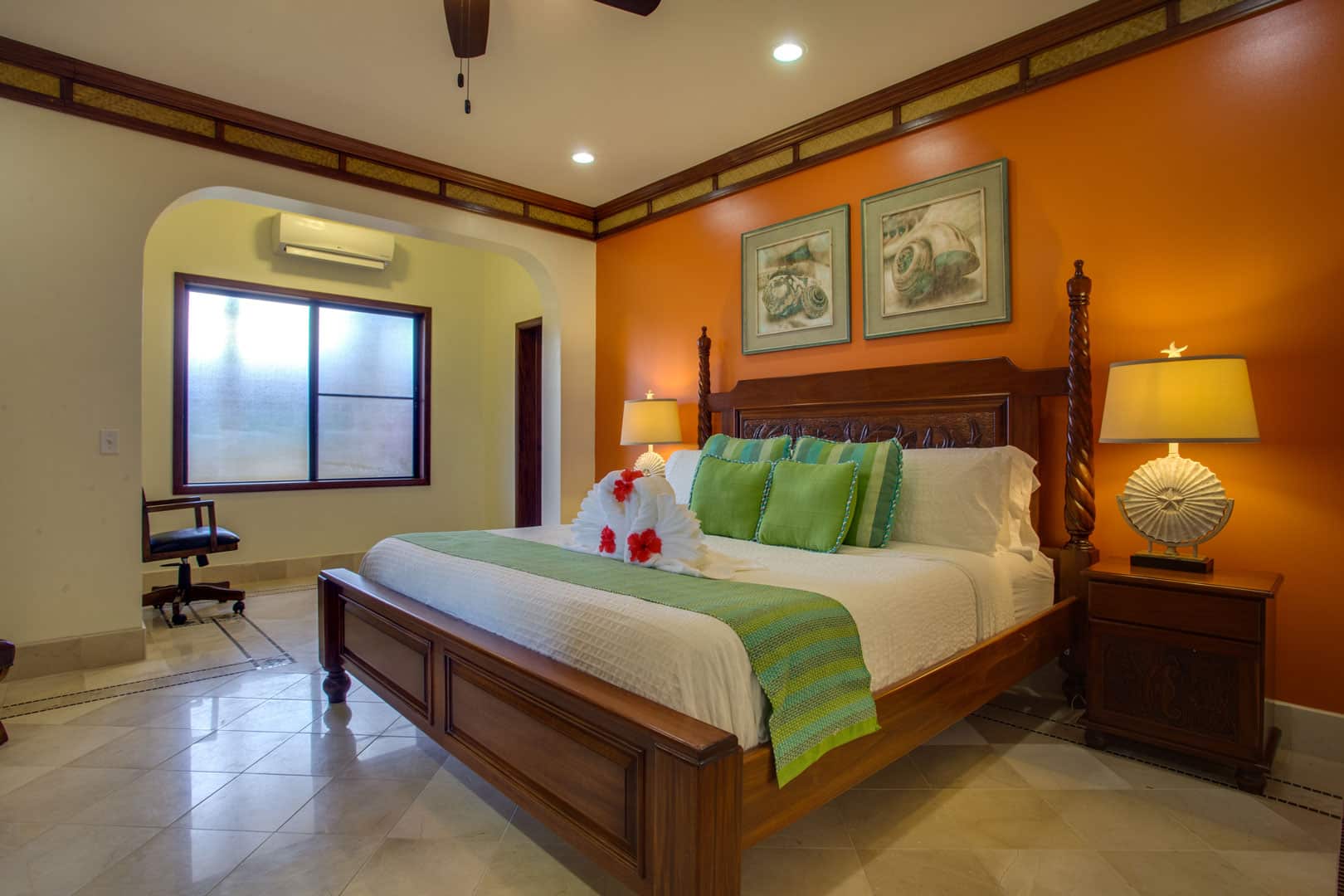 The master bedroom with a king sized bed, two night stand and night lamps inside the Villa Margarita Beachfront Deluxe Rooms at The Resort at Almond Beach