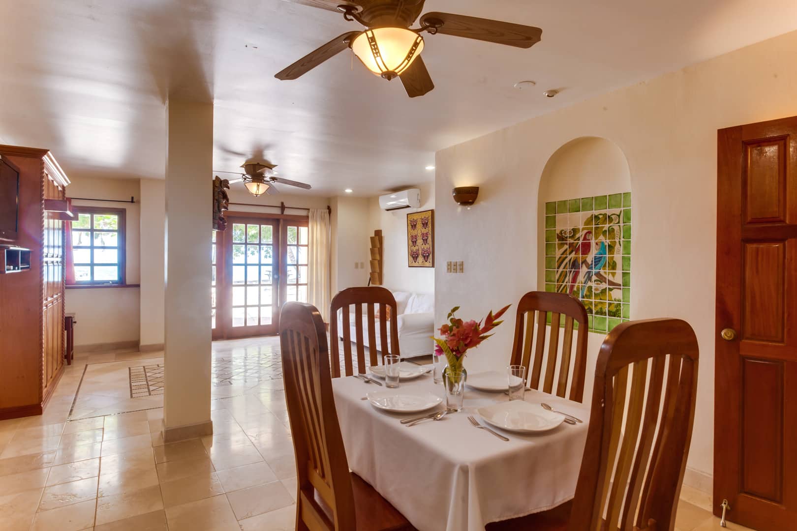 Dining area with a wooden dining table and four chairs inside the One Bedroom Beachfront Suites at The Colonial Inn