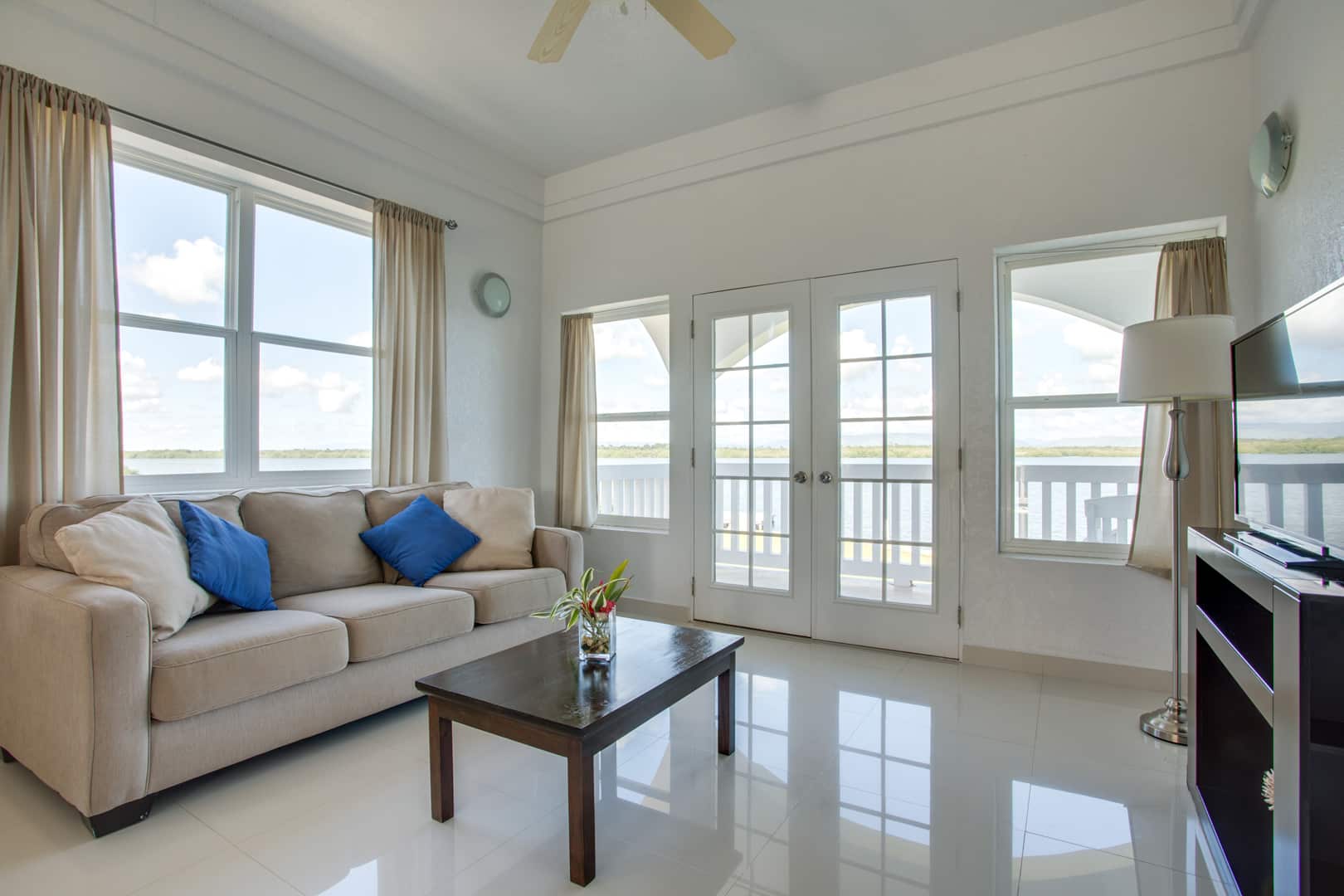 Living room with a white couch, a small wooden coffee table and a television inside of the 2 Bedroom Penthouse Lagoon Bayview at Umaya Resort & Adventure