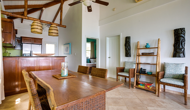 The dining area with a wooden dining table and four chairs inside of the 2 Bedroom Penthouse Beachfront at Umaya Resort & Adventure