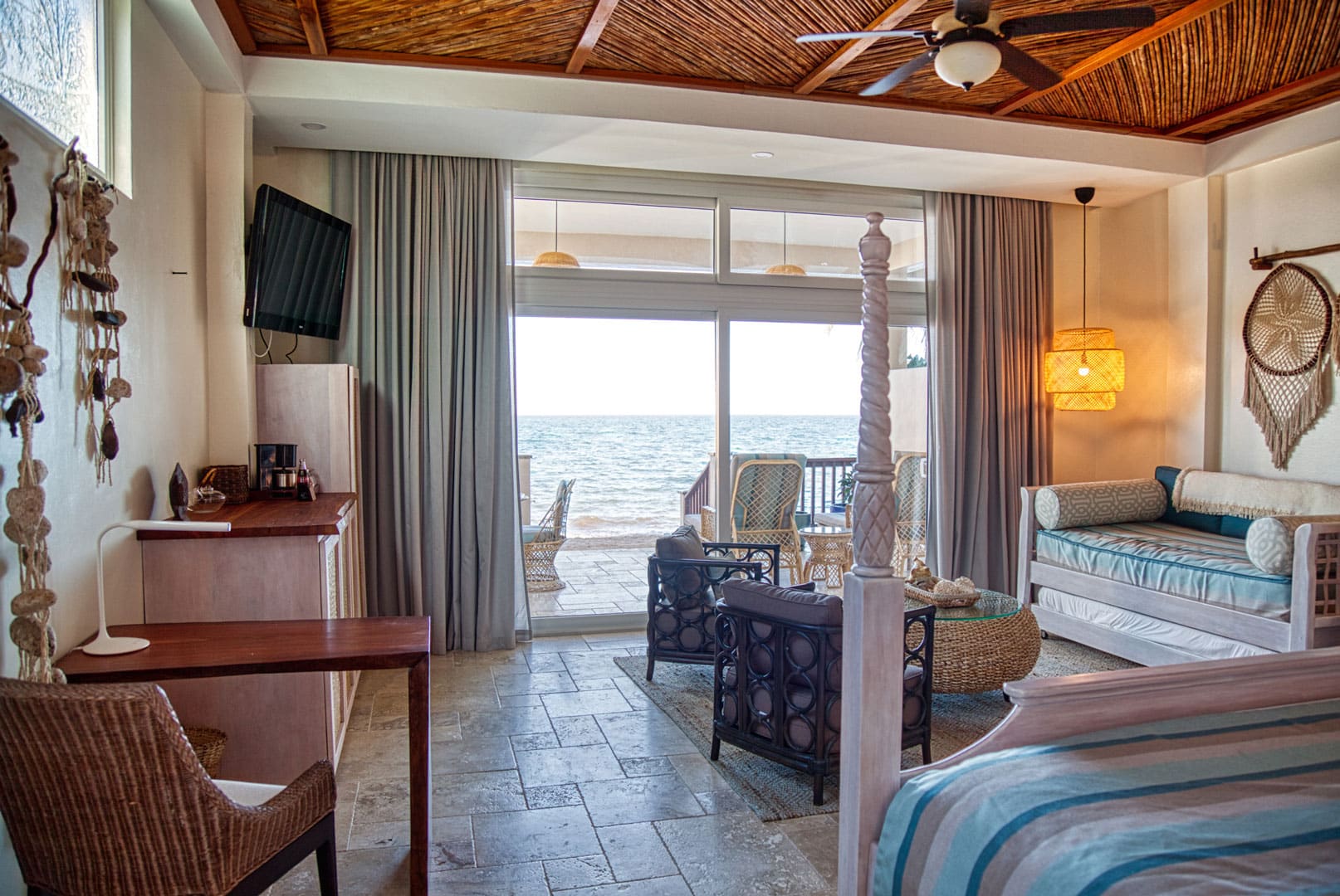 Living room area with view of the front porch and the sea view of the Beachfront Spa Rooms at The Resort at Almond Beach