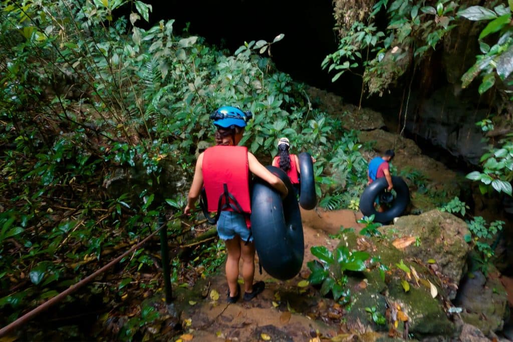 A group of guess hiking to St. Herman's Cave for the St. Herman’s Cave Tubing Adventure at The Rainforest Lodge at Sleeping Giant Resort