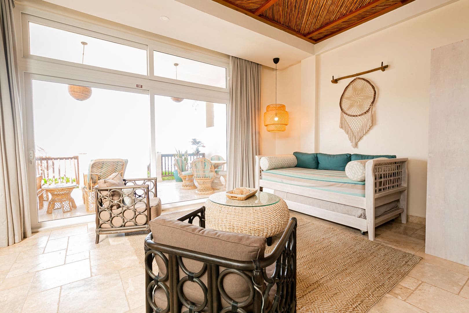 Living room area with couch, center table and 2 wooden chairs inside the Beachfront Spa Rooms at The Resort at Almond Beach