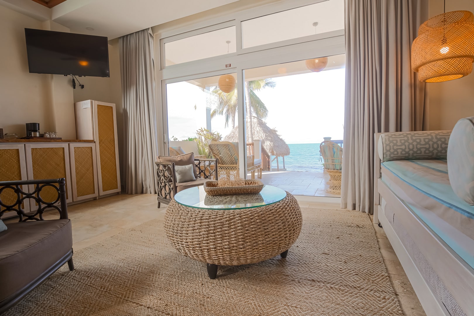 Living room area with a center table and television inside of the Beachfront Spa Rooms at The Resort at Almond Beach