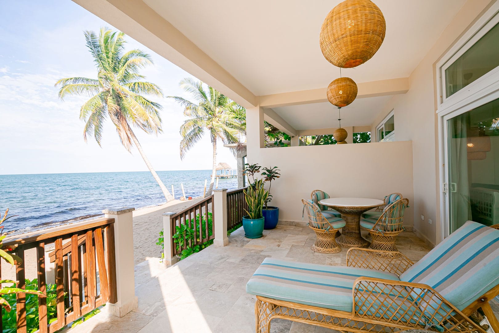 Front porch with a table and a set of chairs and a lounge chair outside of the Beachfront Spa Rooms at The Resort at Almond Beach