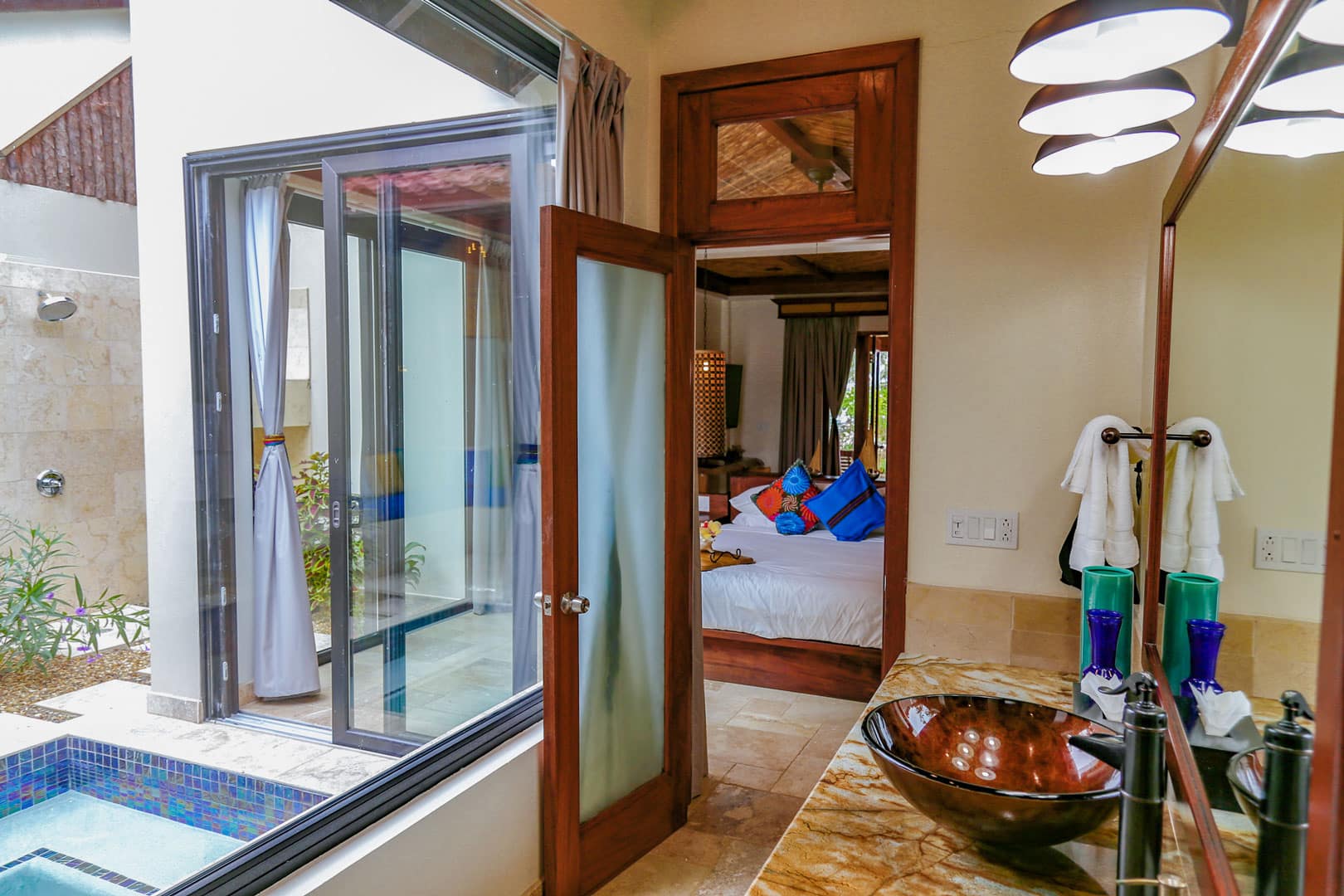 Master bathroom with vanity mirror and sink inside the Deluxe Suites at The Resort at Almond Beach