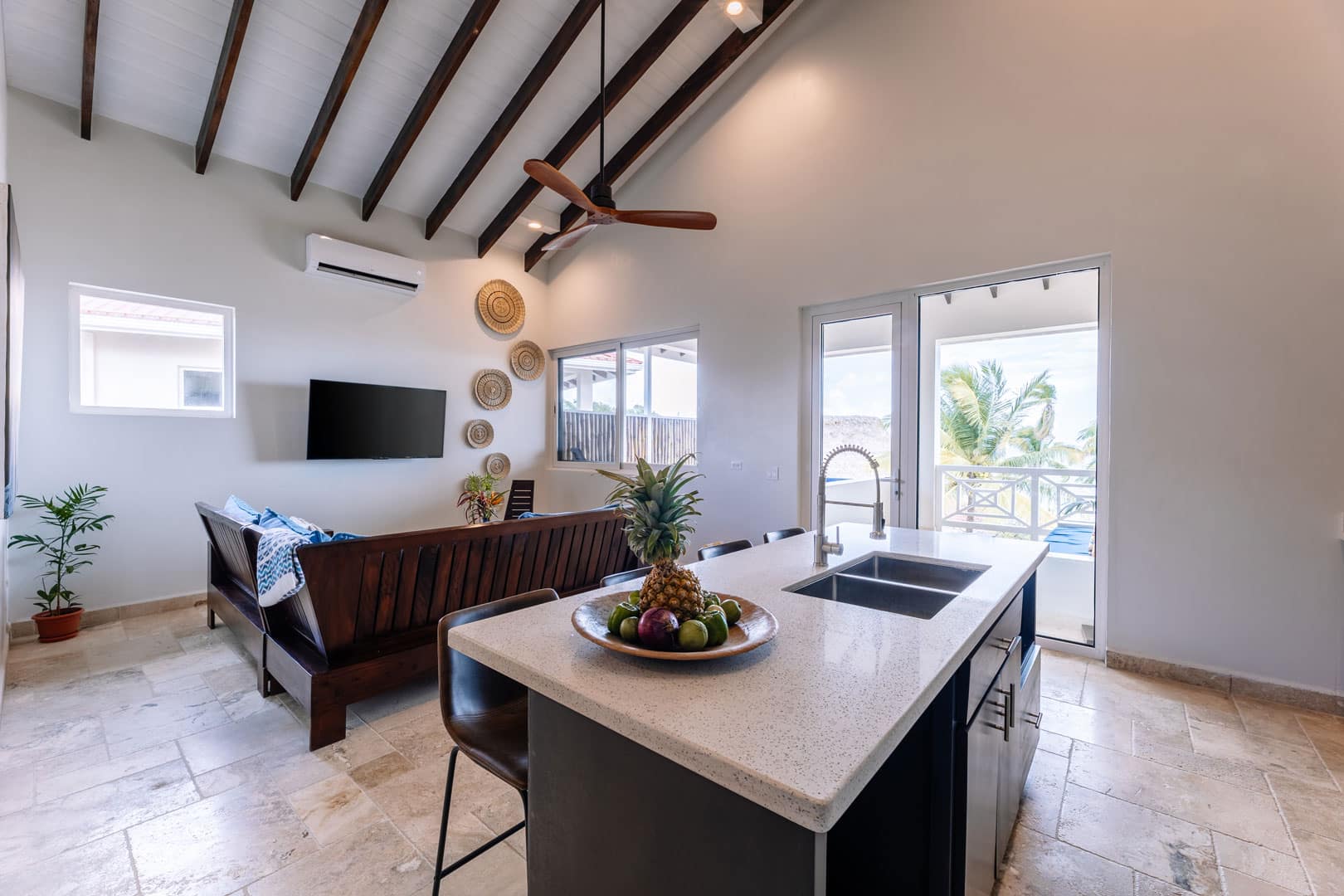 Living room and kitchen area inside of the 2 Bedroom Penthouse with Plunge Pool at The Lodge at Jaguar Reef Resort