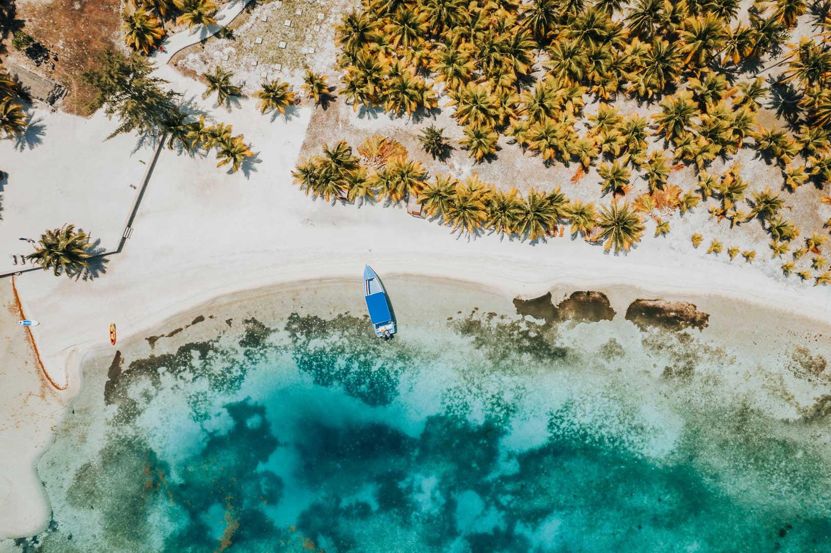 Aerial drone shot of the beach at Rhythm Reef Caye by The Belize Collection