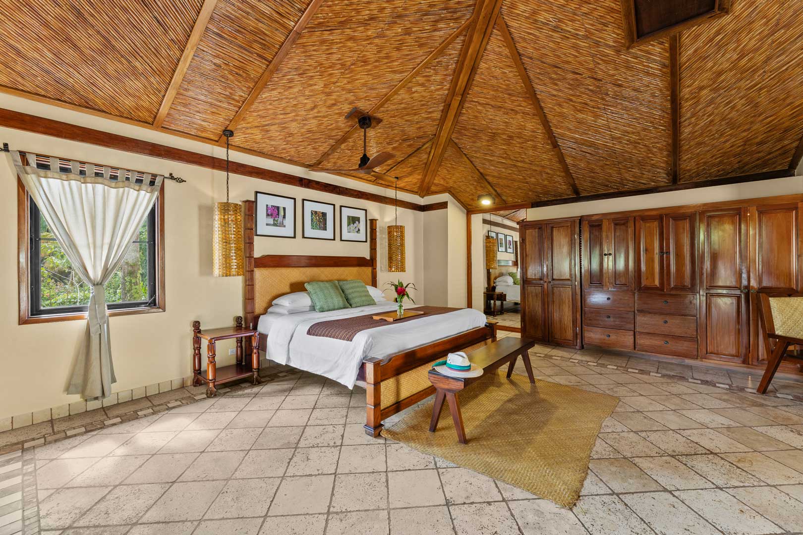 Bedroom view with a bed and a wall of closet and drawers inside of the Jungle Cottage with Plunge Pool at The Rainforest Lodge at Sleeping Giant Resort