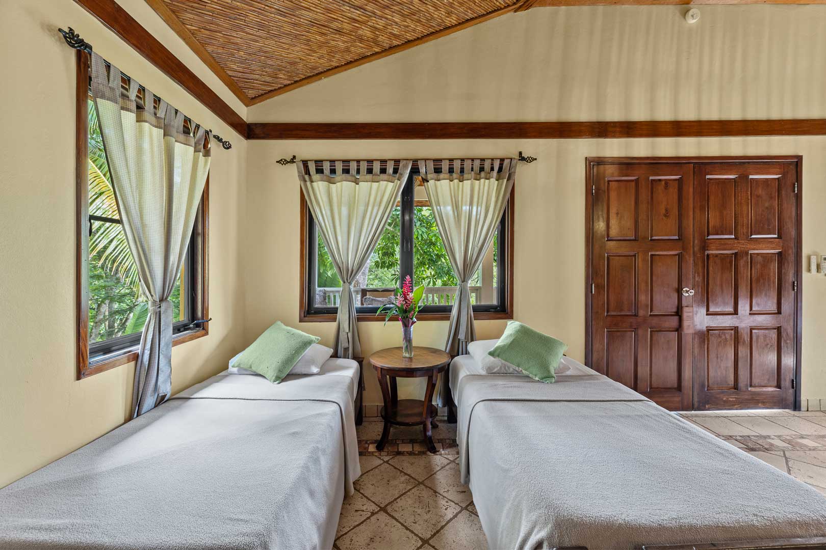 Two single beds being show inside the bedroom of the Jungle Cottage with Plunge Pool at The Rainforest Lodge at Sleeping Giant Resort