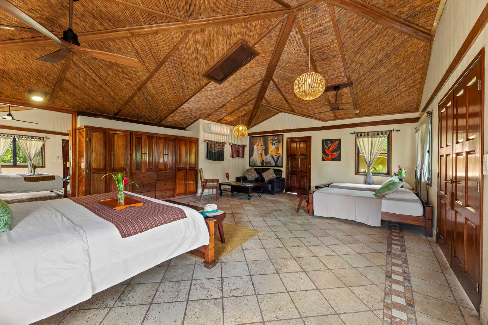 Bedroom view with a queen sized bed and two single beds inside of the Jungle Cottage with Plunge Pool at The Rainforest Lodge at Sleeping Giant Resort