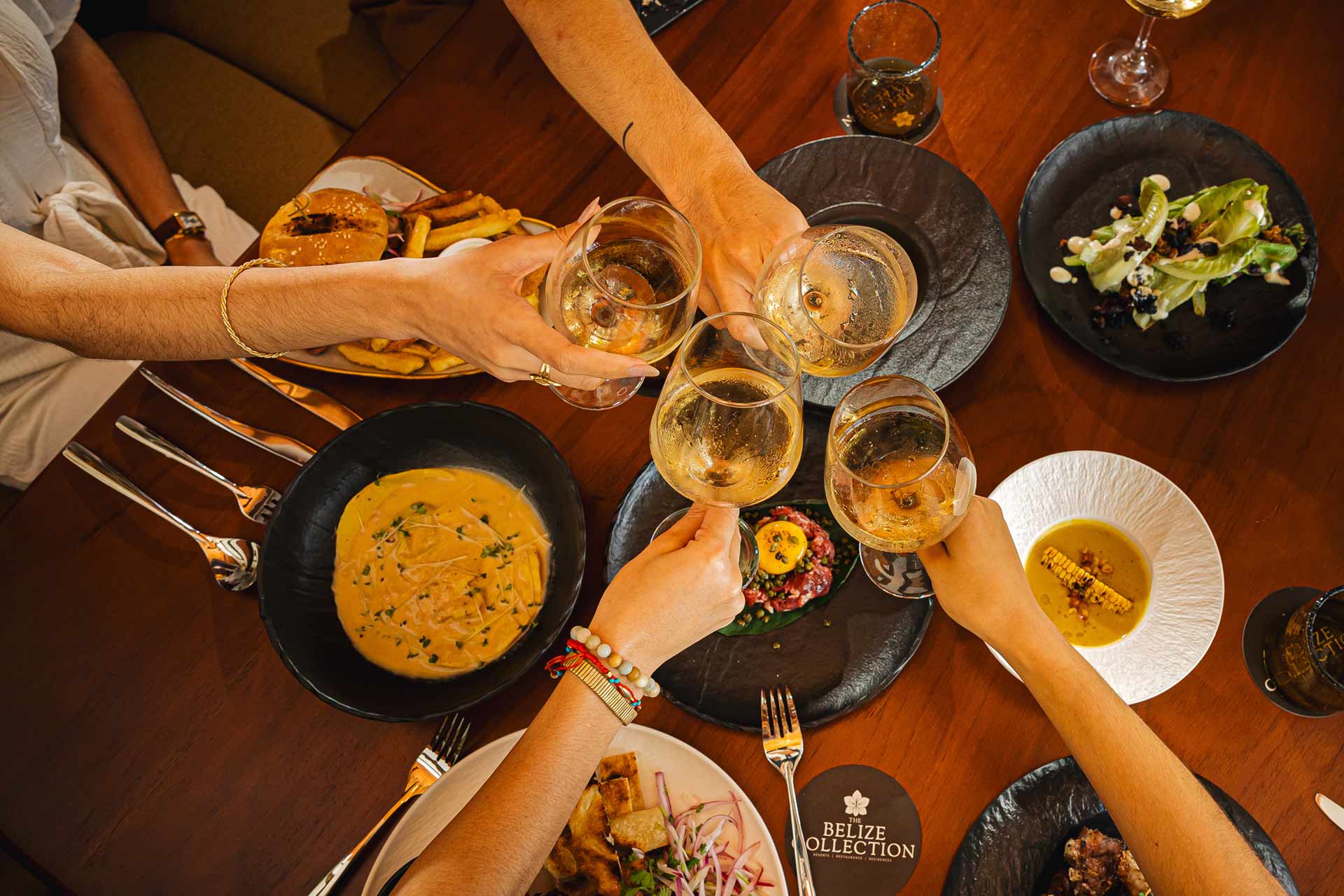 Group of guests enjoying food and drinks at Humo Restaurant, The Banks Resort, Belize