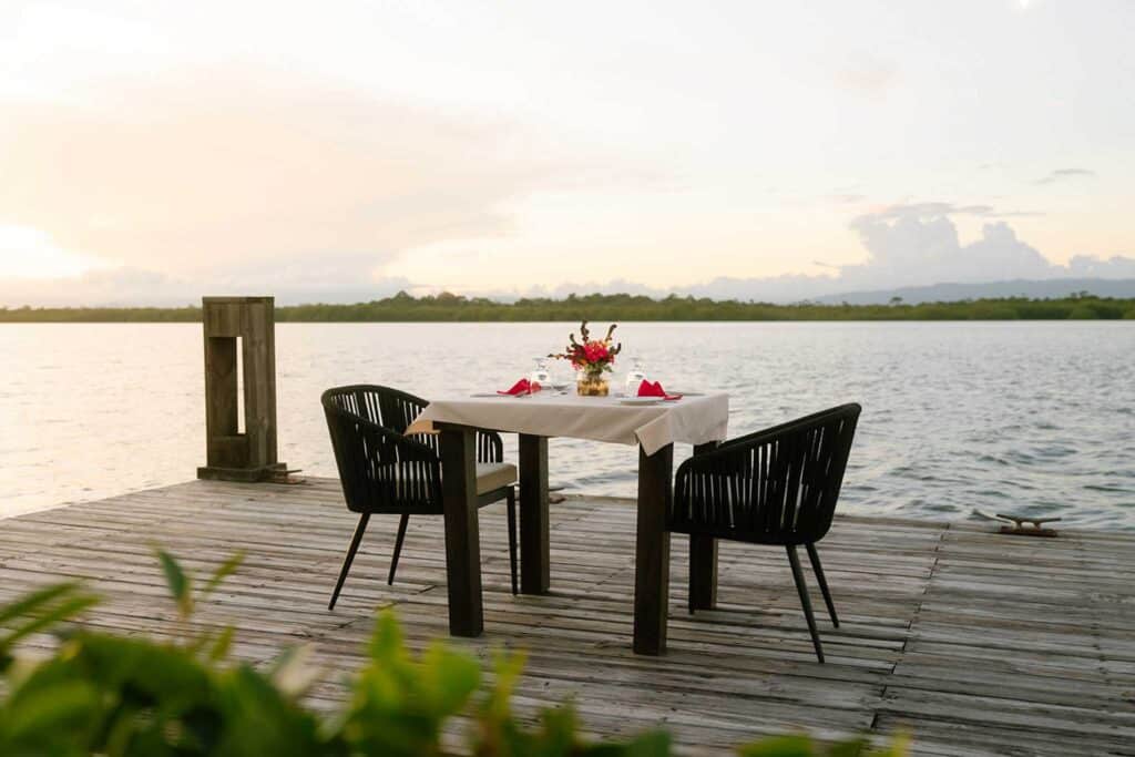 Elegant lagoonside sunset dining arrangement at Umaya Resort on the Placencia Peninsula, Southern Belize