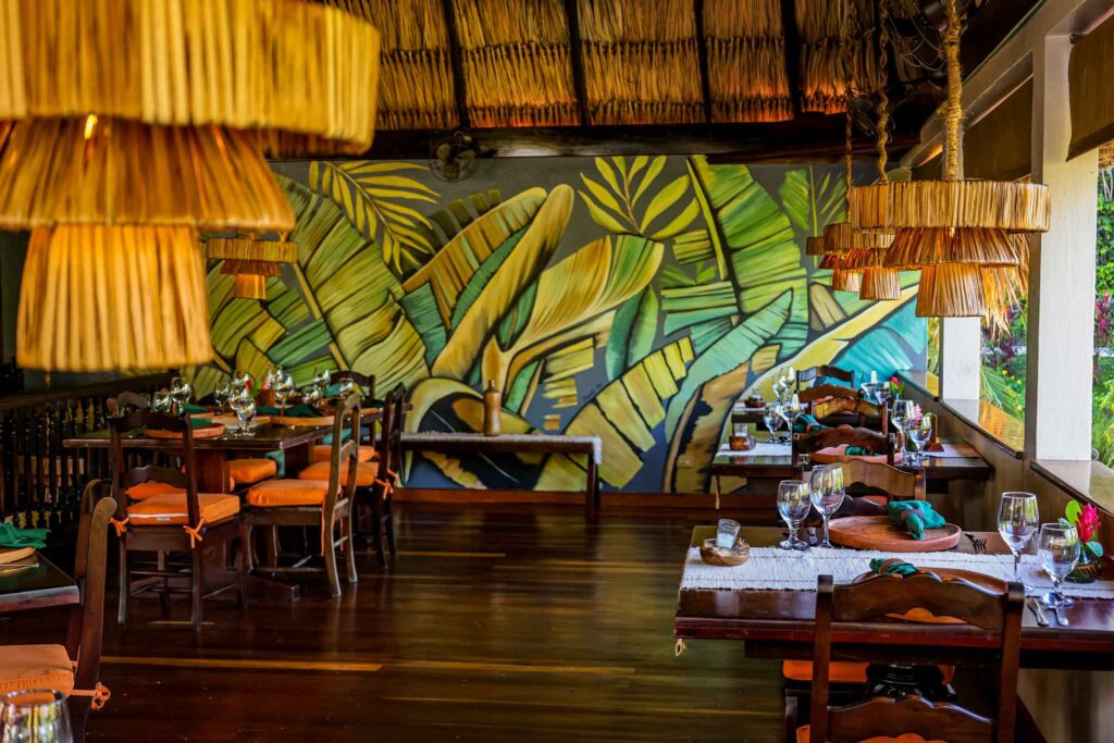 Vibrant open-air conference meeting setup at Sleeping Giant Rainforest Lodge with elegant table settings, floral decor, and a lush jungle vibe.