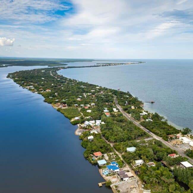 Aerial view of the Placencia Peninsula, Belize, showing the lagoon, beachside, and the narrow strip of land between them.