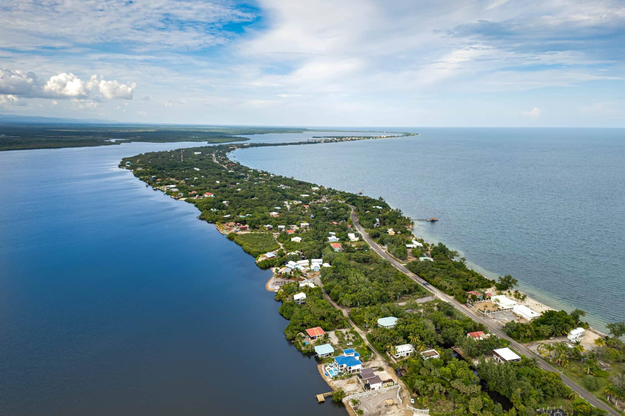Aerial view of the Placencia Peninsula, Belize, showing the lagoon, beachside, and the narrow strip of land between them.
