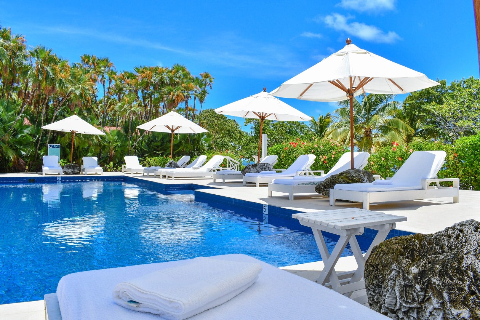 The pool at Naia Resort with lounge chairs and umbrellas